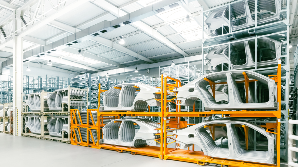 Car hulls in an early production stage, stacked in a manifacturing facility.