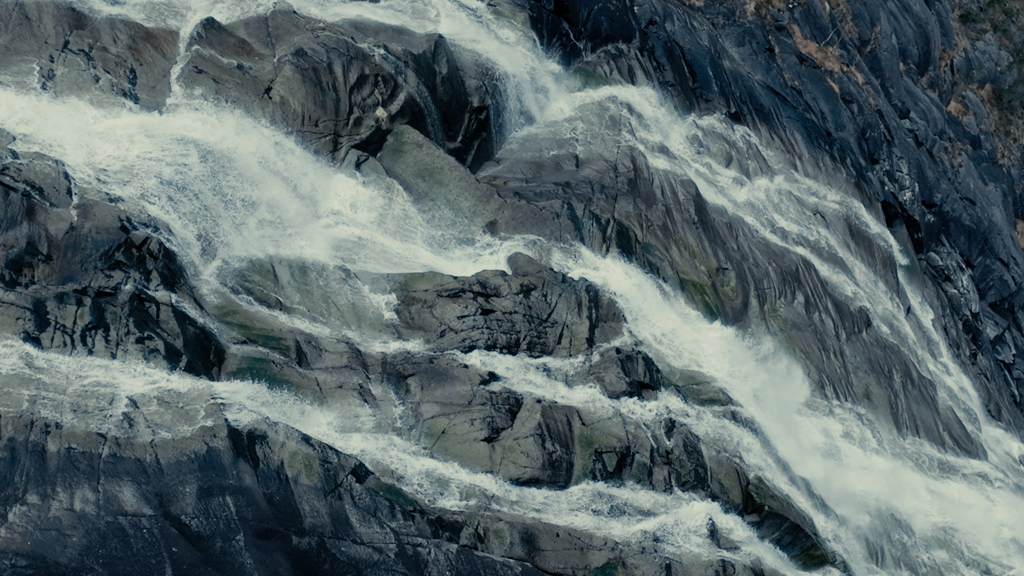 A waterfall going along a stony mountain wall.