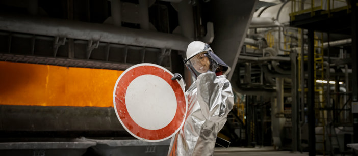 A Speira employee holds up a road sign before it is recycled.