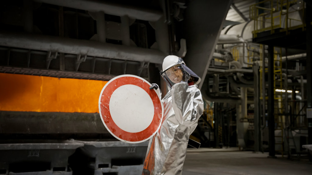 A Speira employee holds up a road sign before it is recycled.