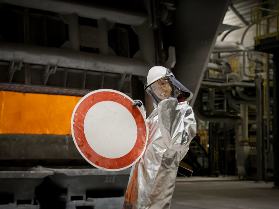 A Speira employee holds up a road sign before it is recycled.