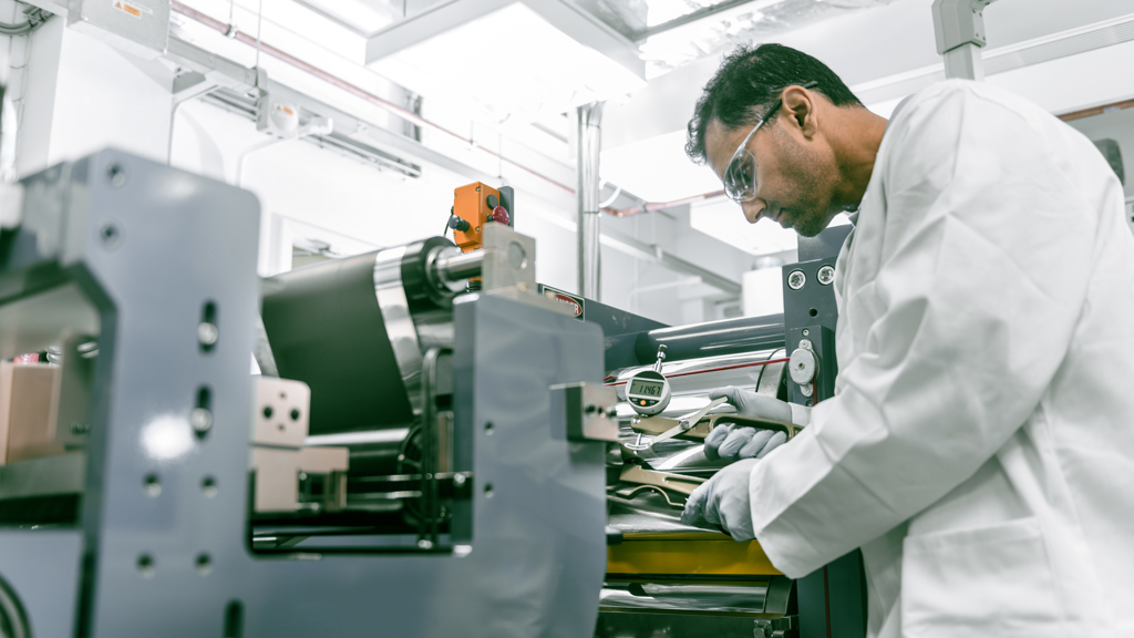 Scientist in Speira laboratory examining the quality of a piece of aluminum.