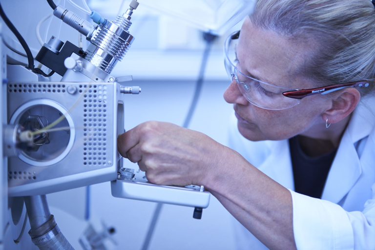 A laboratory technician from Speira inspects a materials testing device.