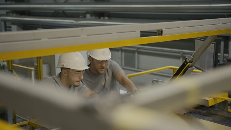 Zwei Speira Mitarbeiter prüfen Aluminiumblech für die weitere Produktion.