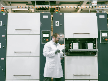 Scientist in Speira laboratory examining the quality of a piece of aluminum.