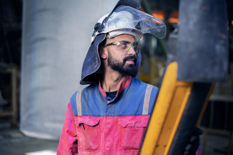 A Speira employee in work clothes stands in one of the Speira plants.