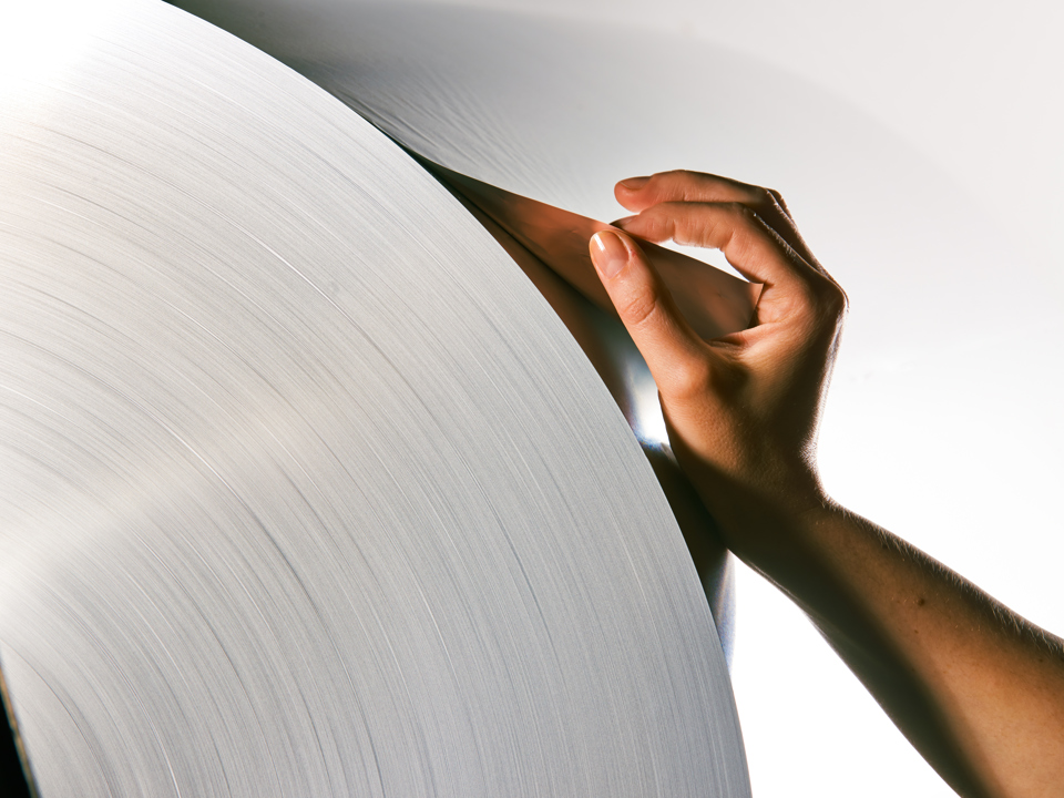 Hand gently holding the end part of an aluminium coil.