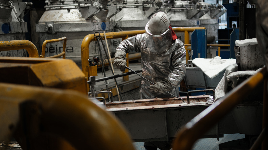 Speira employees in heat-protective clothing during an aluminum production phase.