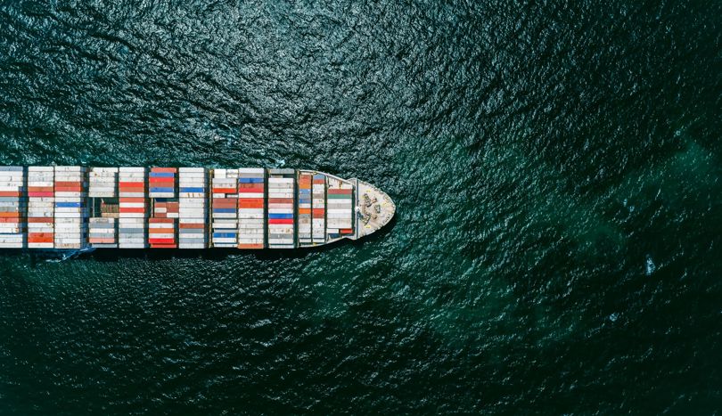 Large containership with components made of aluminium sailing across the sea.